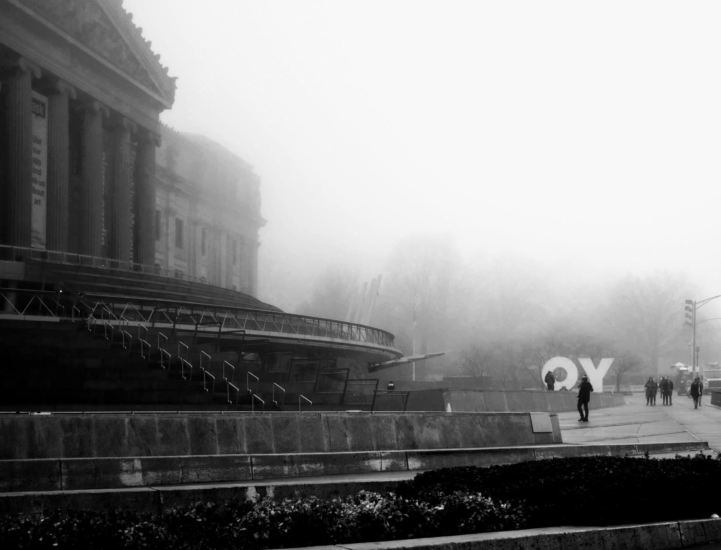 Photo of the Brookly Museum surrounded by fog with large letters Yo cut through